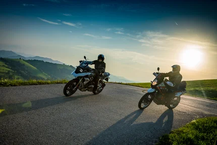 Oberösterreich © Moppetfoto.de Zwei Motorradfahrer auf einem kurvigen Bergweg bei Sonnenuntergang