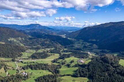 Slowenien © Igor Rosina Luftaufnahme eines grünen Bergtals mit verstreuten Häusern und bewaldeten Hängen