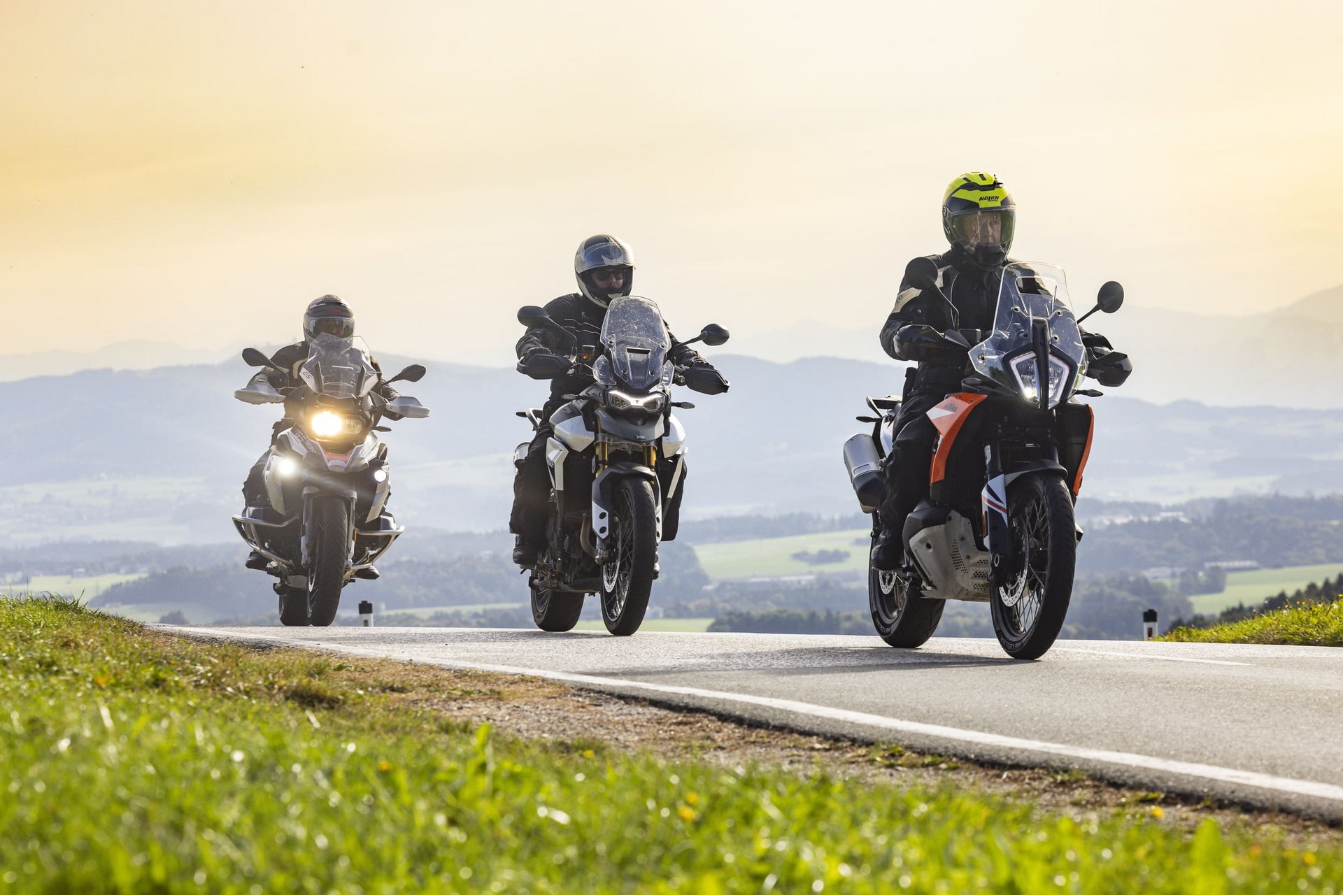 Motorradurlaub © Heiko Mandl Drei Motorradfahrer fahren auf einer Landstraße mit Hügeln im Hintergrund