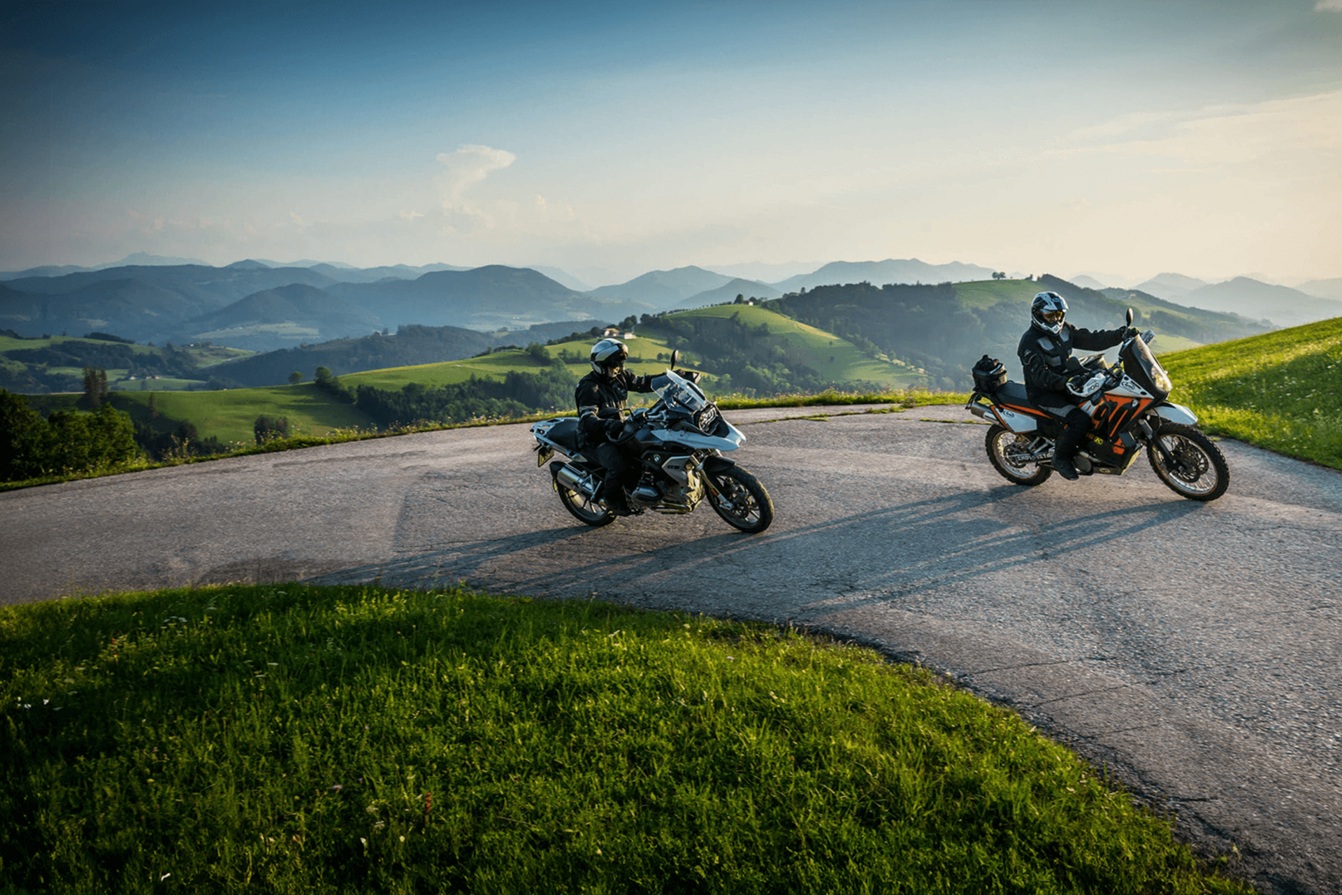 Motorvakantie Twee motorrijders op kronkelende bergweg bij zonnig weer