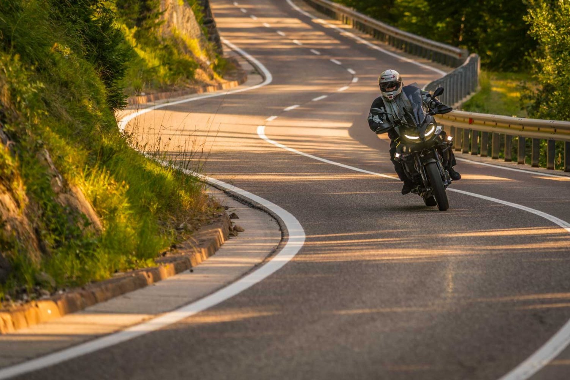 Motorradurlaub © Moppetfoto.de Motorradfahrer auf kurviger Landstraße in sonniger Landschaft