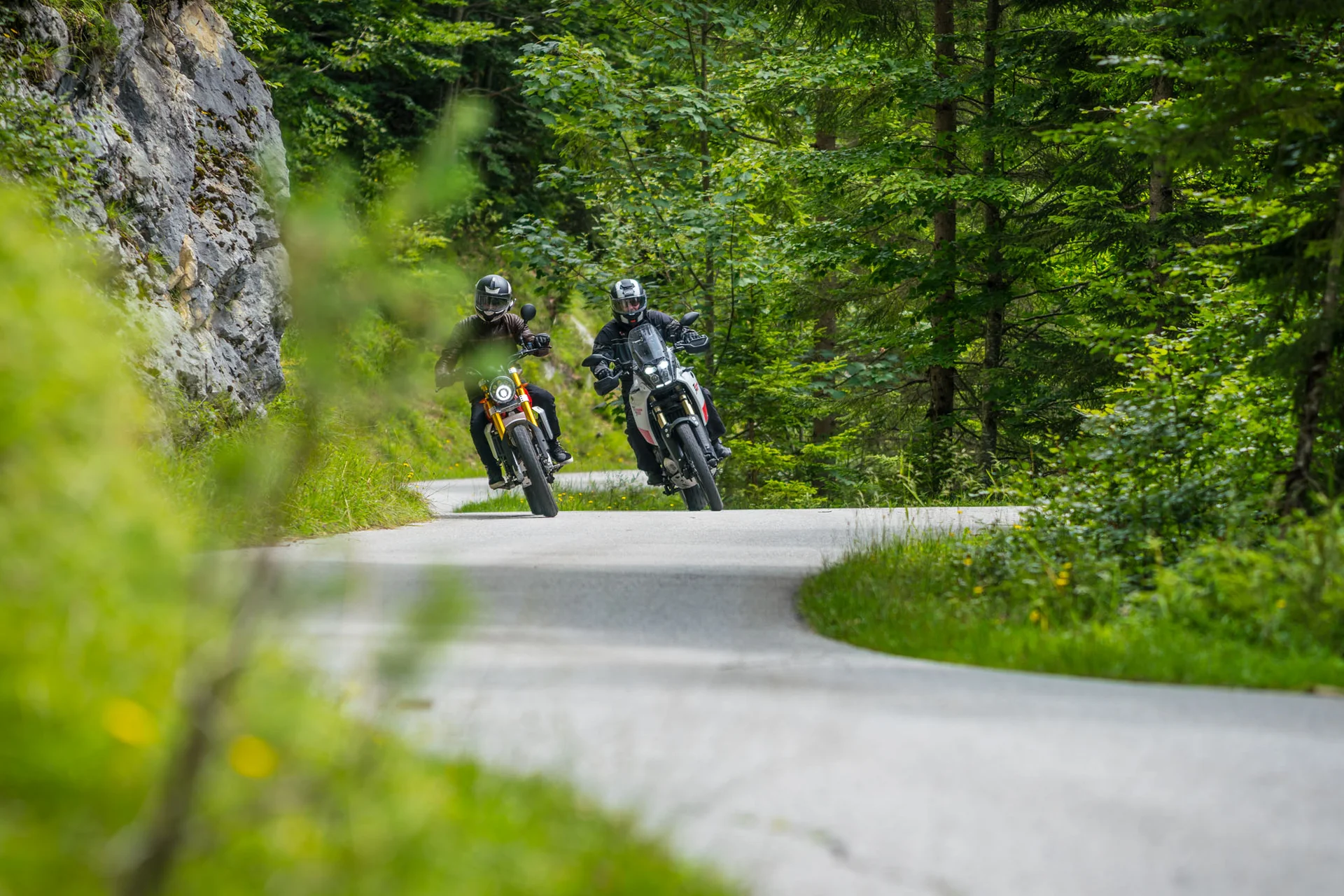 Motorvakantie © Moppetfoto.de Twee motorrijders op kronkelende weg door groen bos