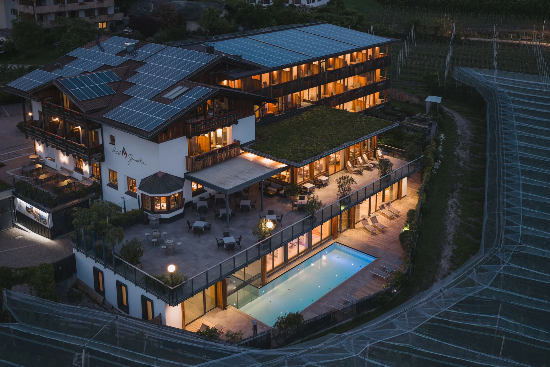 Motorvakantie © Upscale Hotel met zonnepanelen op het dak en verlicht zwembad 's nachts