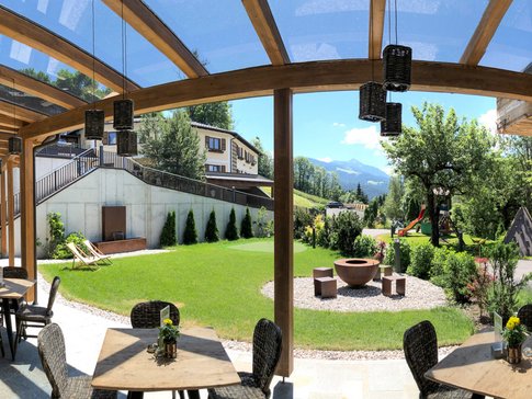 Landhotel & Gasthof Laudersbach © Manuel Jäger Overdekt terras met tafels, stoelen en uitzicht op bergen in een tuin