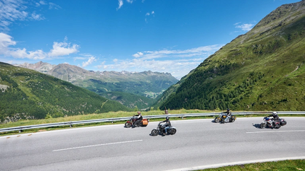 Südtirol Runde Vier Motorradfahrer fahren auf kurviger Bergstraße bei klarem Himmel