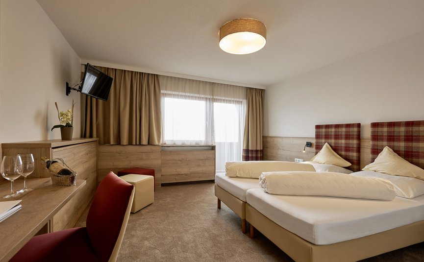 Alpenhotel Laurin ***S © studio22.at - Marcel Hagen Gemütliches Hotelzimmer mit Doppelbett und Fernseher