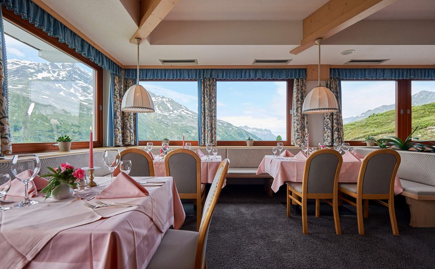 Alpenhotel Laurin ***S © studio22.at - Marcel Hagen Restaurant mit Fensterblick auf verschneite Berge und pink gedeckte Tische
