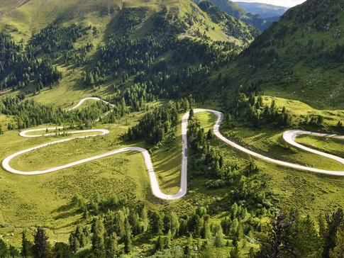 Niedere Tauern - Nockalm Kronkelende bergweg door groen heuvelachtig landschap