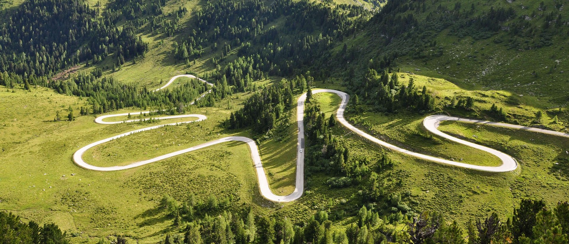 Motorvakantie Kronkelende bergweg door groen heuvelachtig landschap