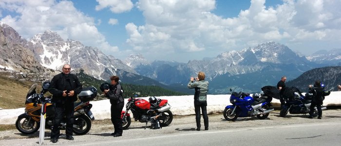 MOAR'S Hotel ***S © MOAR's Hotel in Olang Motorradfahrer an einer Bergstraße mit schneebedeckten Bergen und blauem Himmel