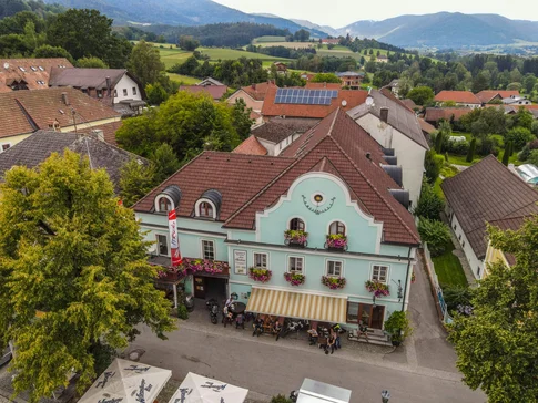 Gasthof Pension Drei Hacken © Alexander Seger Oude herberg met blauwe gevel en bloemen in een dorp met bergen op de achtergrond