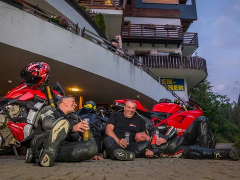Bike & Ski Hotel Diana Karersee © Moppetfoto.de Drie motorrijders zittend lachend met drankjes bij rode motorfietsen