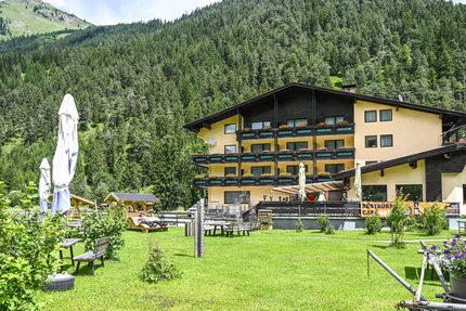 Schönauer Hof © Schönauer Hof - Porsche Geel alpenhotel met tuin en beboste berg op de achtergrond in de zomer