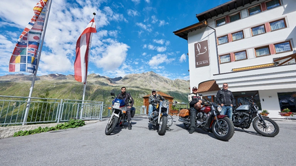 Drei mal Tirol - 2-Tagestour Vier Männer auf Motorrädern vor einem Hotel mit Bergkulisse und Fahnen