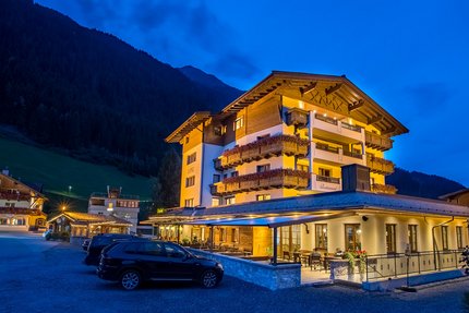 Hotel - Wirtshaus Lenz Verlicht berghotel 's nachts met geparkeerde auto's ervoor