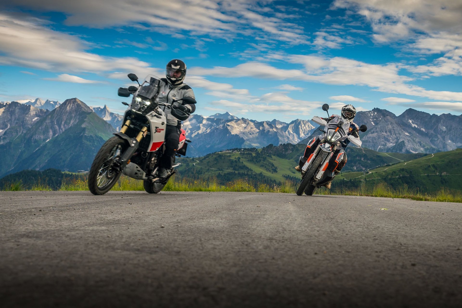 Motorradurlaub © Moppetfoto.de Zwei Motorradfahrer fahren auf einer Bergstraße mit Alpen im Hintergrund