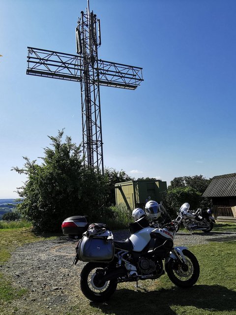 Motorradurlaub © Leberzipf Didi Motorräder vor einem großen metallischen Kreuz auf einem Hügel