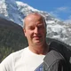 Motorradurlaub © Hotel Bergblick Mann hält Motorradhelm und Jacke vor verschneiten Bergen