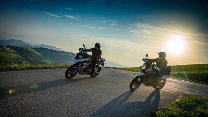 Oberösterreich © Moppetfoto.de Zwei Motorradfahrer auf einem kurvigen Bergweg bei Sonnenuntergang