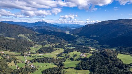 Slowenien © Igor Rosina Luftaufnahme eines grünen Bergtals mit verstreuten Häusern und bewaldeten Hängen
