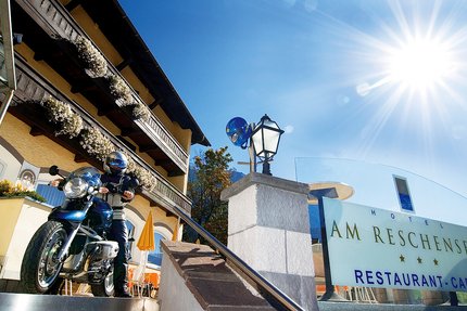Hotel am Reschensee © The Dilitz Company GmbH Motorradfahrer vor Hotel Am Reschensee an sonnigem Tag