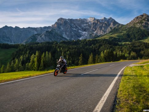 Hochkönig Motorcyclist riding on mountain road with mountains and forest behind