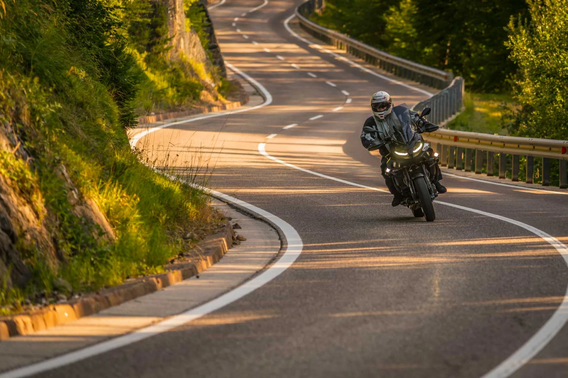 Motorradurlaub © Moppetfoto.de Motorradfahrer auf kurviger Landstraße in sonniger Landschaft