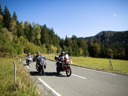 Savinja Tal © Matic Šuc Motorradfahrer fahren auf Landstraße durch grüne Landschaft bei klarem Himmel