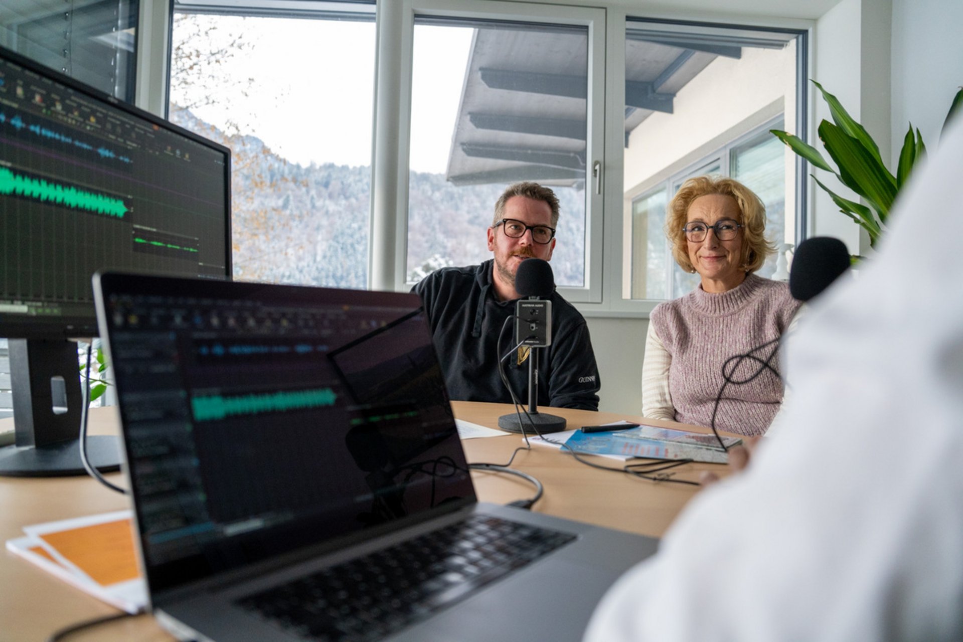 Motorradurlaub © Benedikt Foidl Drei Personen nehmen in einem hellen Raum ein Interview mit Mikrofonen auf.