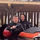 Motorradurlaub © Hotel La Stüa Mann und Frau auf orangem Motorrad unter Holzdach