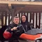 Motorradurlaub © Hotel La Stüa Mann und Frau auf orangem Motorrad unter Holzdach