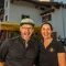 Motorradurlaub © Moppetfoto.de zwei lächelnde personen vor hotel mit motorrädern im hintergrund