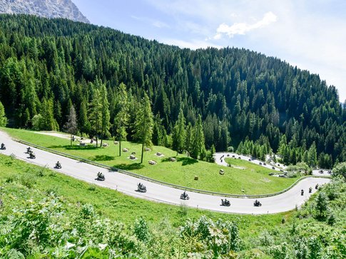 Valsugana - Kaiserjägerstrasse - Val di Fiemme © Daniele Rodorigo Motorcyclists riding on a winding mountain road through green forests