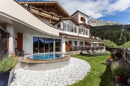 Hotel Obereggen © Stefan Mair Hotel mit Whirlpool und Liegestühlen vor Berglandschaft
