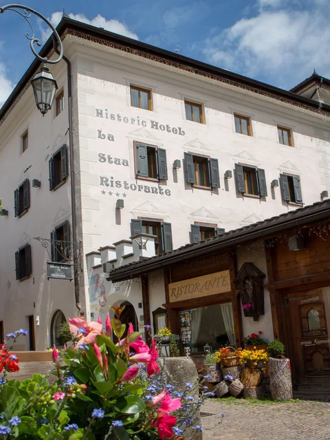 Motorradurlaub © Hotel La Stüa Historisches Hotel und Restaurant La Stua mit Blumen im Vordergrund