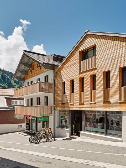 Motorradurlaub © Mathies Wilhelm Robert jun. Straße mit modernen Häusern aus Holz und Stein unter blauem Himmel