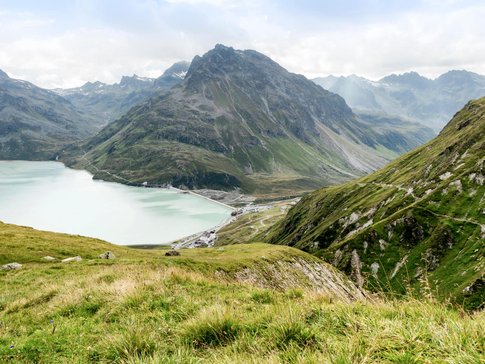 Paznaun - Silvretta © Montafon Tourismus GmbH - Andreas Haller Mountain lake and green alpine slopes under cloudy sky