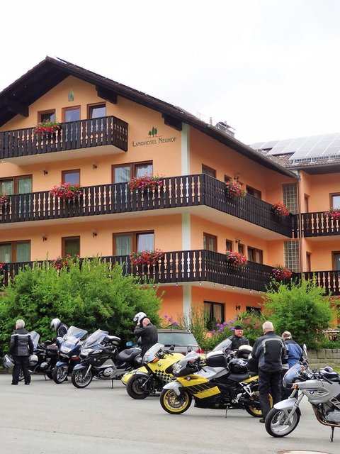 Motorradurlaub © Landhotel Neuhof Zenting Motorradfahrer vor Landhotel mit Balkonen und Blumen