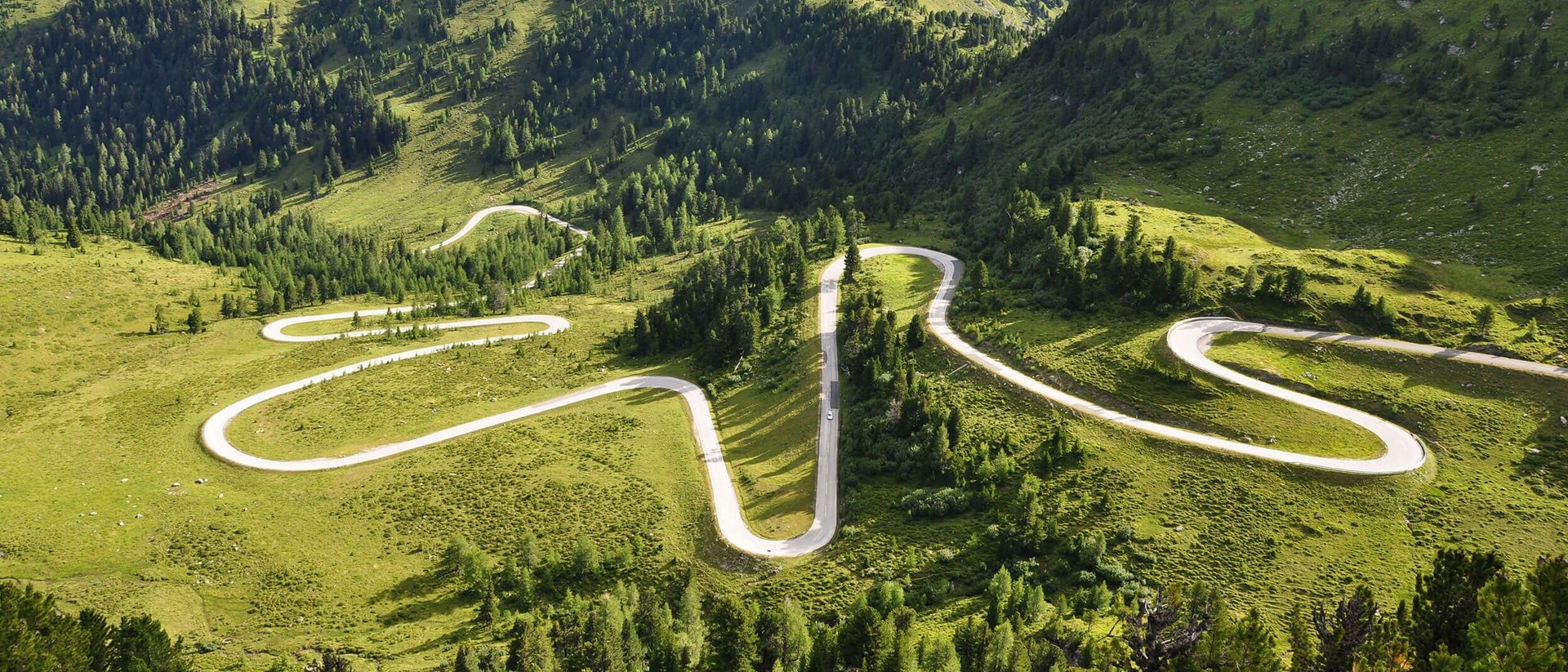 Nockalmstraße © Land Kärnten - Nockalmstraße - Großglockner Hochalpenstraßen AG Kurvige Bergstraße durch grüne Landschaft und Hügel