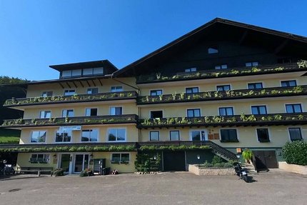 Gast-Hof-Laden Schneeweiss © Gast-Hof-Laden Schneeweiss Groot rustiek chalet met balkonplanten onder heldere lucht