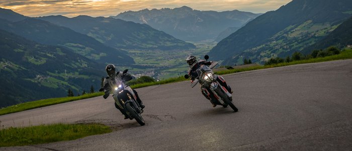 Hotel Sonnleiten *** © Moppetfoto.de Two motorcyclists riding on winding mountain road at sunset in the Alps