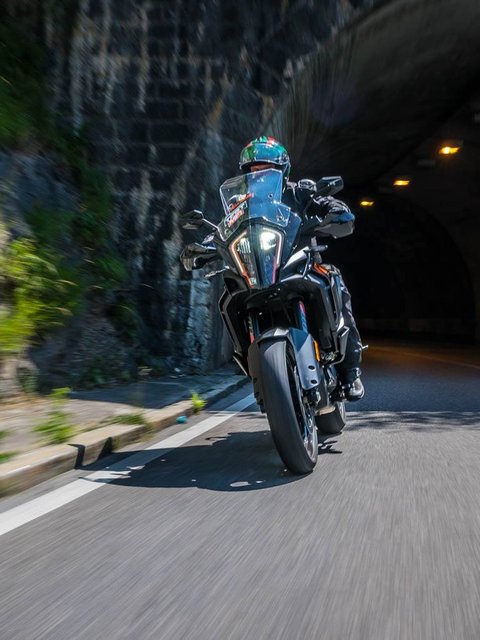 Motorradurlaub © Moppetfoto.de Motorradfahrer fährt in einem Tunnel an Felswand vorbei