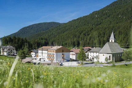 Hotel Gasthof Zum Hirschen © Hotel Zum Hirschen Dorf mit Kirche und Bergen im Hintergrund bei sonnigem Himmel