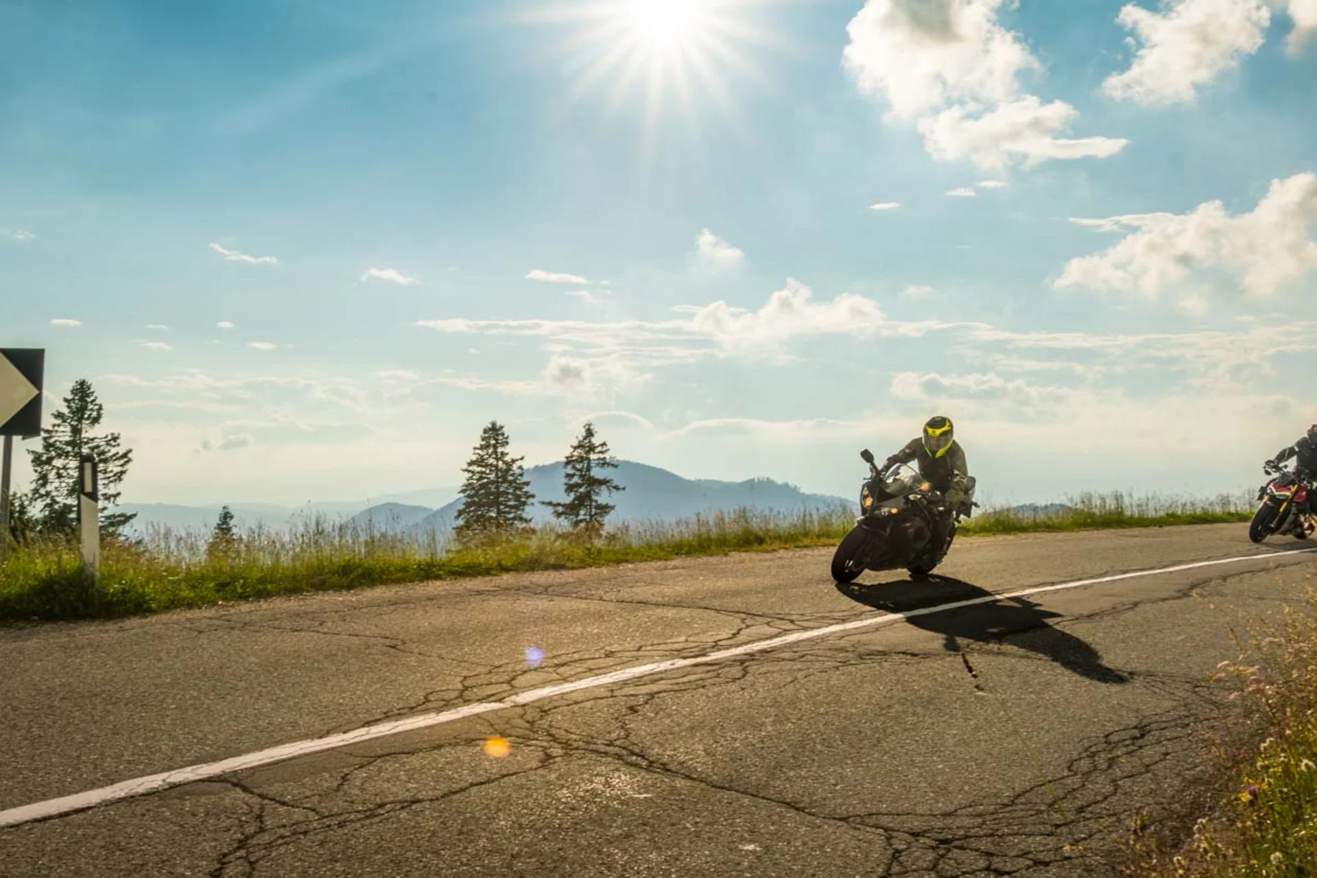 Motorradurlaub © Moppetfoto.de Zwei Motorräder fahren an sonnigem Tag eine kurvige Bergstraße entlang