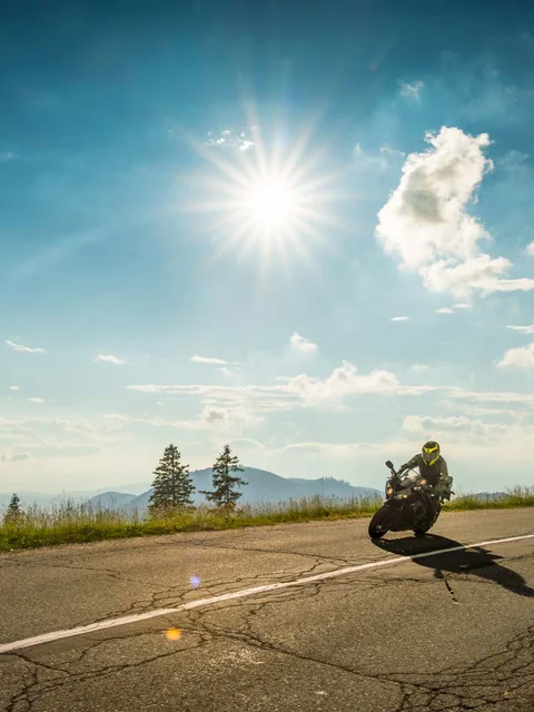 Motorradurlaub © Moppetfoto.de Zwei Motorräder fahren an sonnigem Tag eine kurvige Bergstraße entlang