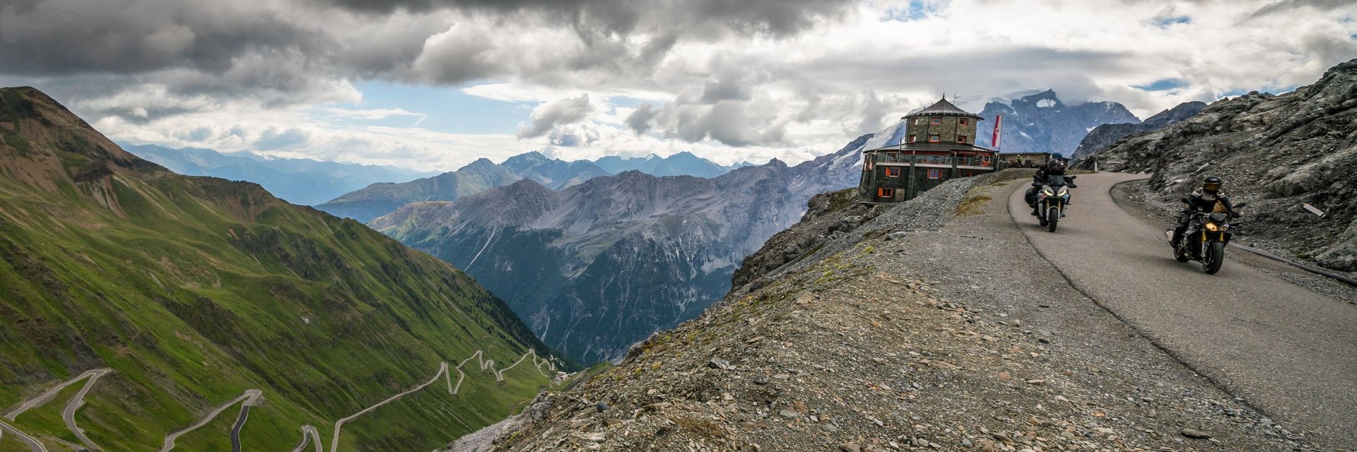 Moto Fun Anna *** © Moppetfoto.de Motorcyclists on winding mountain road under dramatic cloudy sky