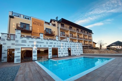 Wohlfühlhotel Rockenschaub © Wohlfühlhotel Rockenschaub Hotelgebäude mit Außenpool bei klarem Himmel