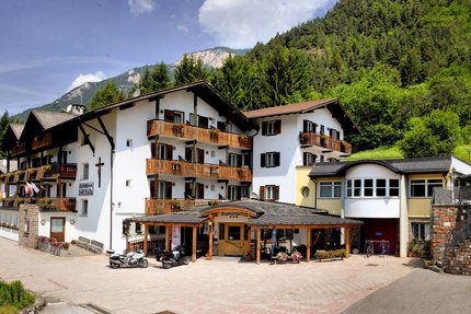 Albergo Panorama © Albergo Panorama Hotelgebäude mit Balkonen und Motorrädern vor Bergwald im Hintergrund