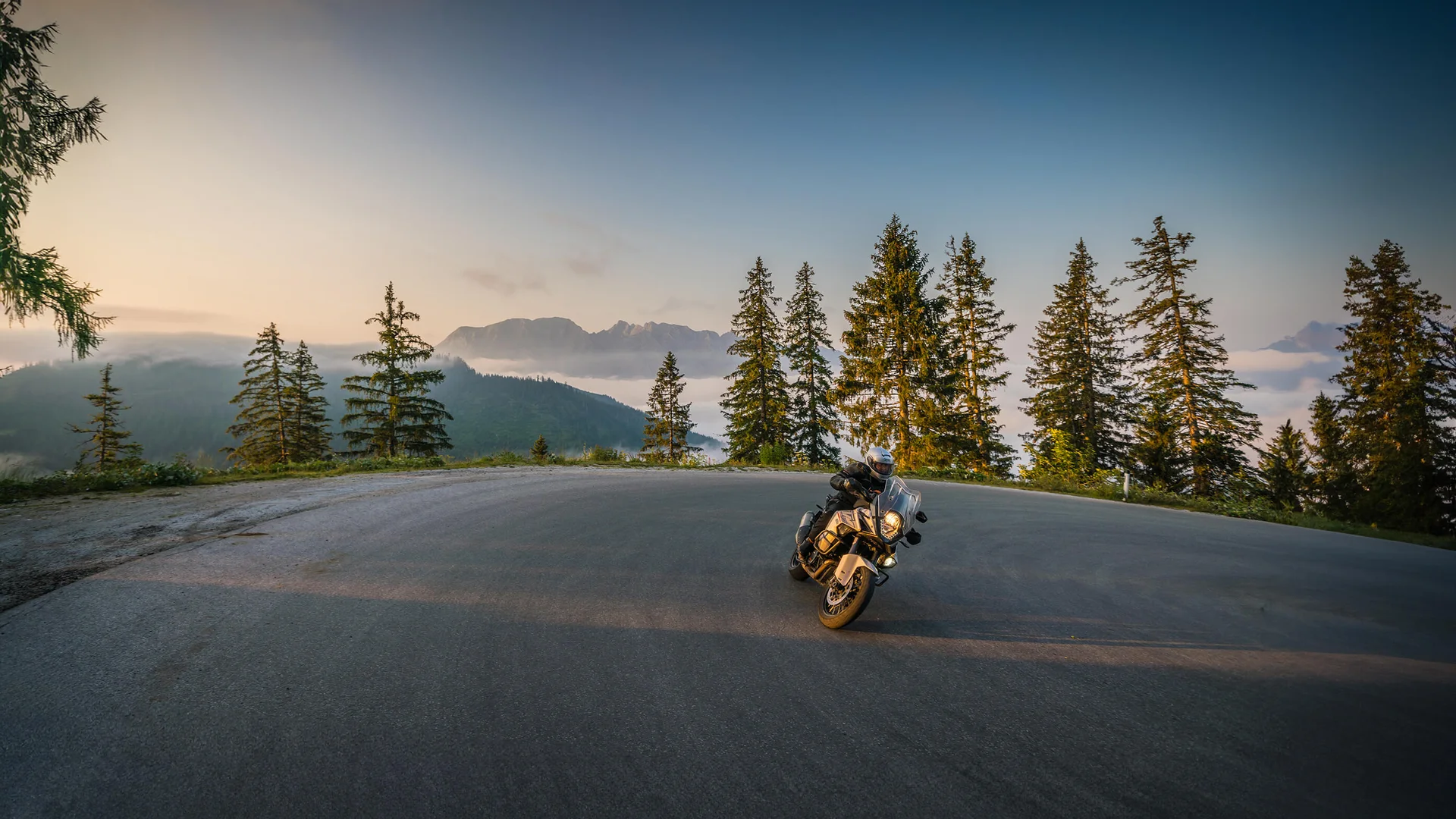 Motorradurlaub © Moppetfoto.de Motorradfahrer auf kurviger Bergstraße bei Sonnenuntergang