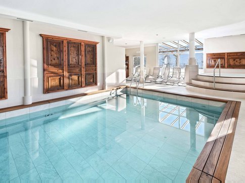 Hotel & Südtiroler Gasthaus Der Gassenwirt © Hotel Gassenwirt Innenraum mit klarem Innenpool und Whirlpool neben Holzpaneelen